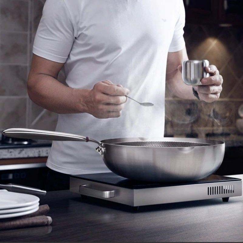 Iwate stainless steel wok with glass lid on ceramic cooktop